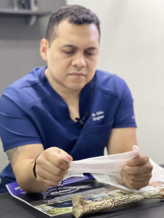 El Dr. Omar Soler examina una malla de reparación de hernia en su consultorio